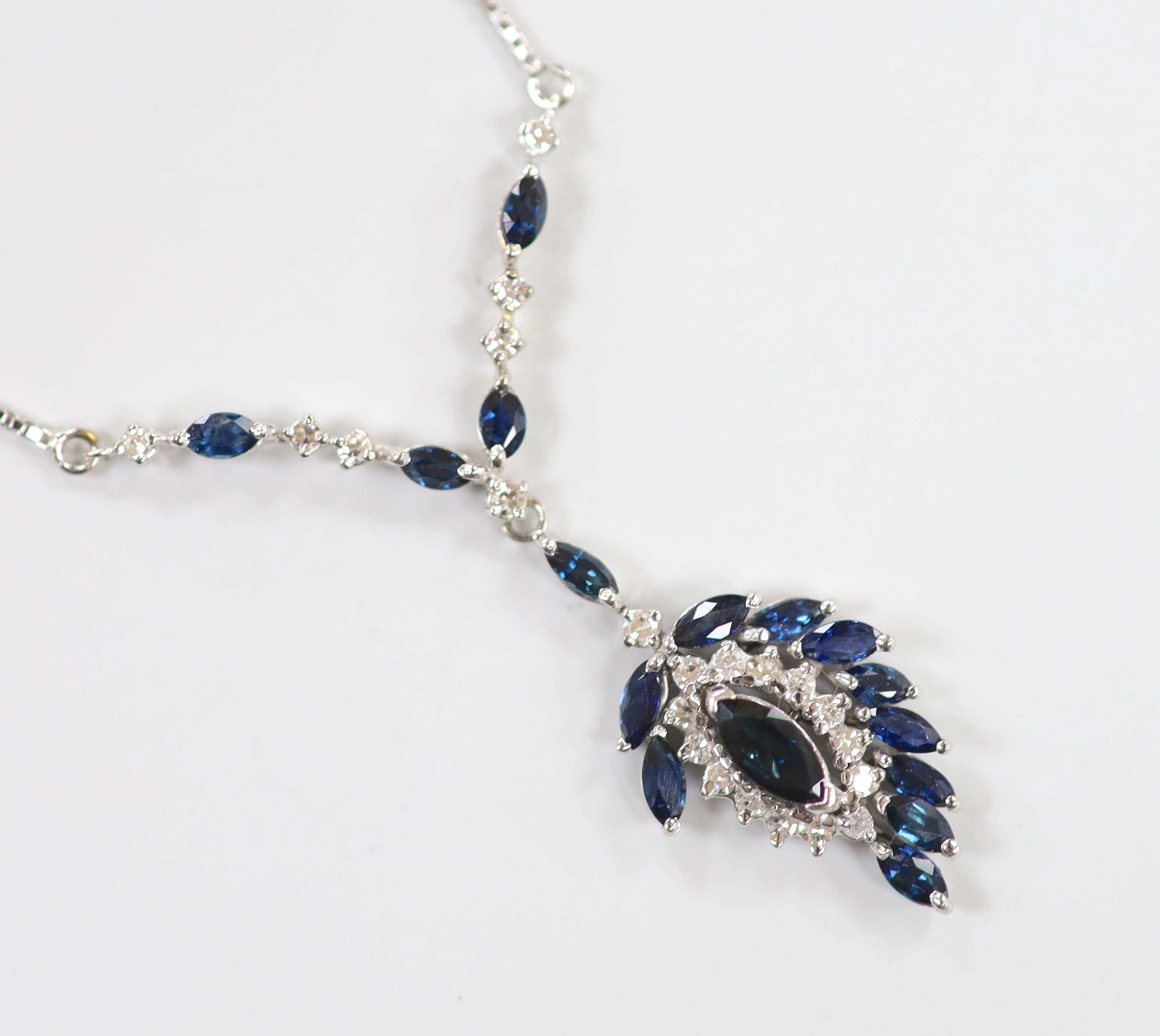 A modern 750 white metal, sapphire and diamond cluster set drop pendant necklace, overall 52cm, gross weight 9.3 grams